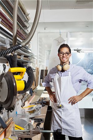 Portrait of a skilled worker standing with hands on hips in workshop Stock Photo - Premium Royalty-Free, Code: 693-06121008