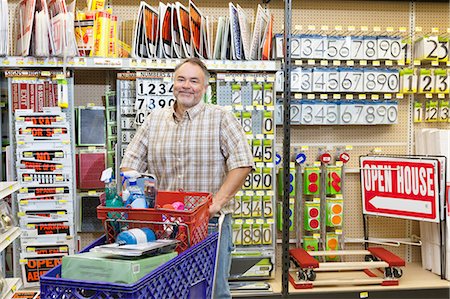showing - Portrait of a mature man with shopping cart in hardware store Stock Photo - Premium Royalty-Free, Code: 693-06121056