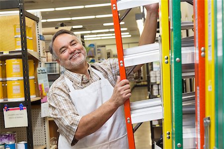 standing ladder - Portrait of a happy mature man with ladder in hardware store Stock Photo - Premium Royalty-Free, Code: 693-06121075