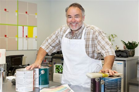 retail clerk - Portrait of a cheerful mature sales clerk with paint can in hardware store Stock Photo - Premium Royalty-Free, Code: 693-06121071