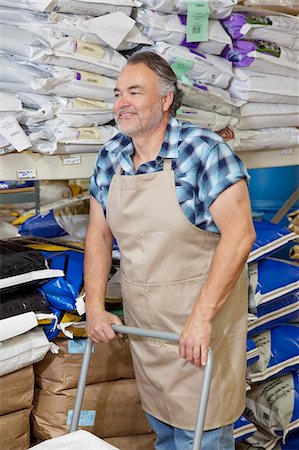 sack - Heureux homme mûr, poussant un chariot dans le magasin de fourrage Photographie de stock - Premium Libres de Droits, Code: 693-06121164