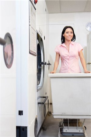 simsearch:693-06120874,k - Portrait of a happy mid adult woman pushing trolley in laundry Stock Photo - Premium Royalty-Free, Code: 693-06121211