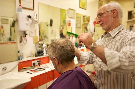 Barber cutting senior man's hair in barbershop Foto de stock - Royalty Free Premium, Número: 693-06121295