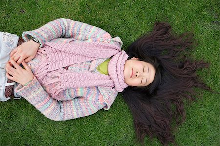 ethnic casual one not eye contact not child - Top view of young Asian woman with long black hair lying on lawn Stock Photo - Premium Royalty-Free, Code: 693-06121317