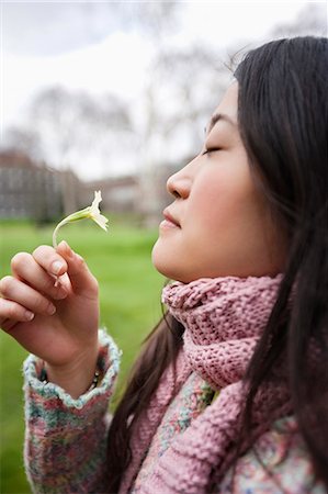 flower park in london - Side view of a young Asian woman smelling flower in park Stock Photo - Premium Royalty-Free, Code: 693-06121318