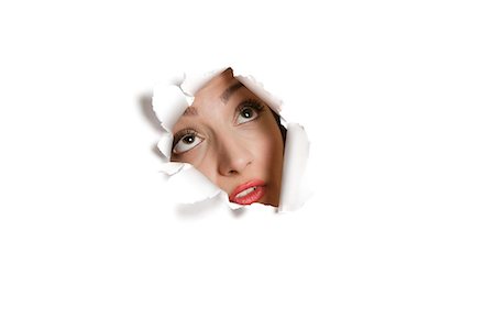 paper people - Young Middle eastern woman looking up from ripped paper hole Stock Photo - Premium Royalty-Free, Code: 693-06121328