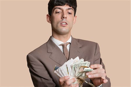 simsearch:693-06324148,k - Young businessman counting money over colored background Stock Photo - Premium Royalty-Free, Code: 693-06121393