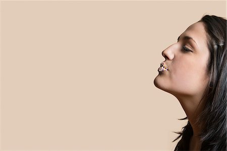 profile woman head and shoulders one person studio shot side view looking away - Side view of young woman with sprinkled lips while looking away over colored background Foto de stock - Sin royalties Premium, Código: 693-06121420