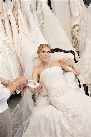 family shopping not groceries - Tired young bride in wedding dress sitting while mother showing footwear Foto de stock - Sin royalties Premium, Código: 693-06324077