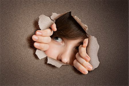 surveiller - Young Middle eastern woman peeking from ripped white paper hole Stock Photo - Premium Royalty-Free, Code: 693-06324089