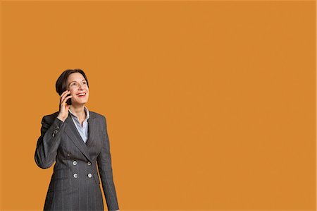 Happy mid adult woman talking on mobile phone Stock Photo - Premium Royalty-Free, Code: 693-06324096