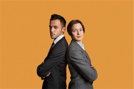 standing side profile - Portrait of a business partners standing back to back with arms crossed Stock Photo - Premium Royalty-Free, Code: 693-06324097