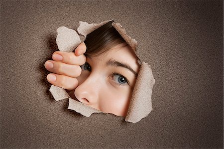 people peeking - Portrait of a young Middle eastern woman peeking from ripped white paper hole Stock Photo - Premium Royalty-Free, Code: 693-06324091