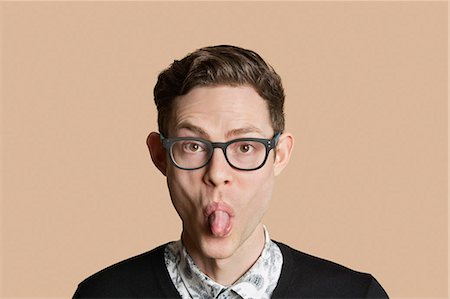 Portrait of a mid adult man sticking out tongue over colored background Foto de stock - Sin royalties Premium, Código: 693-06324152