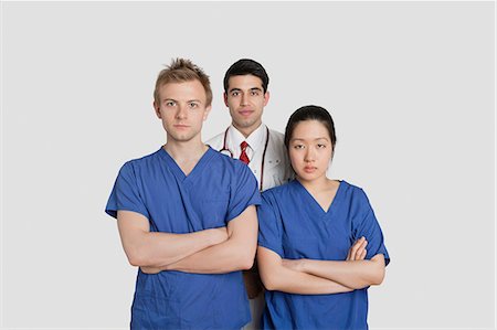 simsearch:693-06324219,k - Portrait des travailleurs de la santé confiants debout sur fond gris Photographie de stock - Premium Libres de Droits, Code: 693-06324244