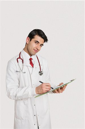 simsearch:693-06324148,k - Portrait of an Indian male doctor writing prescription over light gray background Stock Photo - Premium Royalty-Free, Code: 693-06324251