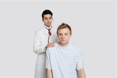 patient gown - Portrait of a male patient being treated by an Indian doctor Stock Photo - Premium Royalty-Free, Code: 693-06324316