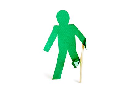 An injured green stick figure with a walking stick over white background Fotografie stock - Premium Royalty-Free, Codice: 693-06324357