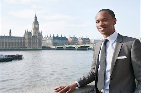 portrait outside work water - Portrait of a smiling African American businessman with buildings in background Stock Photo - Premium Royalty-Free, Code: 693-06324367