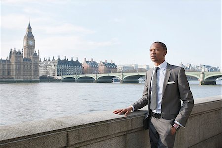 single businessman standing - Young African American businessman looking away with hand in pocket Stock Photo - Premium Royalty-Free, Code: 693-06324369