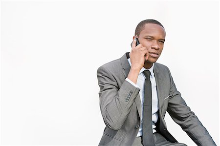 simsearch:693-06435813,k - African American businessman conversing on cell phone over white background Foto de stock - Sin royalties Premium, Código: 693-06324374