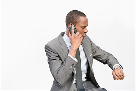 simsearch:693-06379459,k - African American businessman checking time while on a call Stock Photo - Premium Royalty-Free, Code: 693-06324375