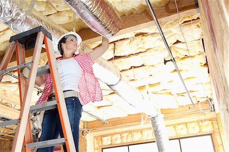 Faible angle vue du travailleur féminin travaillant sur plafond incomplète Photographie de stock - Premium Libres de Droits, Code: 693-06324439