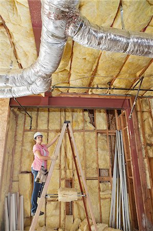 simsearch:693-06324469,k - Female architect moving up the ladder to check incomplete ceiling Stock Photo - Premium Royalty-Free, Code: 693-06324441