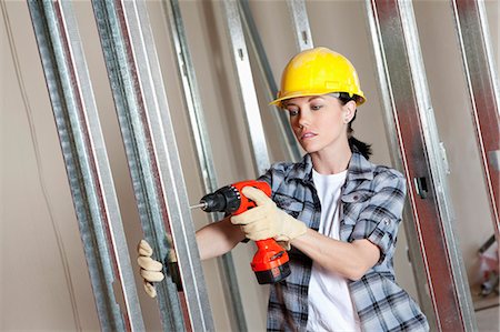 female unbuttoned shirts - Mid adult worker drilling at construction site Stock Photo - Premium Royalty-Free, Code: 693-06324462