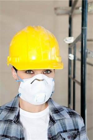 Portrait of woman worker wearing dust mask at construction site Foto de stock - Sin royalties Premium, Código: 693-06324472