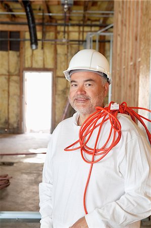 electrical cord - Portrait of a construction worker with a red electric wire Stock Photo - Premium Royalty-Free, Code: 693-06324515