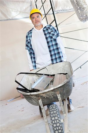 simsearch:693-06324439,k - Male construction worker standing with a wheelbarrow Fotografie stock - Premium Royalty-Free, Codice: 693-06324520