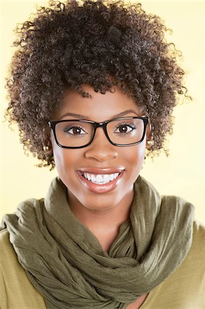 eye wear - Portrait of a happy African American woman wearing glasses with a stole round her neck over colored background Stock Photo - Premium Royalty-Free, Code: 693-06324604