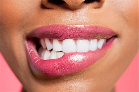 simsearch:693-06324635,k - Close-up view of an female biting her lip over colored background Stock Photo - Premium Royalty-Free, Code: 693-06324637