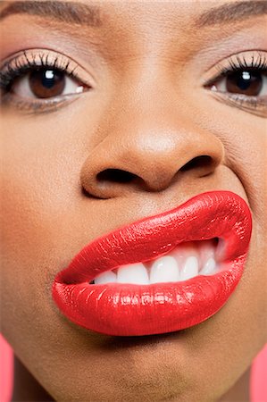 Close-up portrait of young woman with red lips grimacing Stock Photo - Premium Royalty-Free, Code: 693-06324646