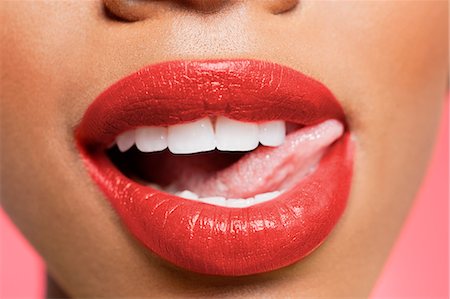 females mouth - Cropped image of woman licking red lipstick Stock Photo - Premium Royalty-Free, Code: 693-06324640