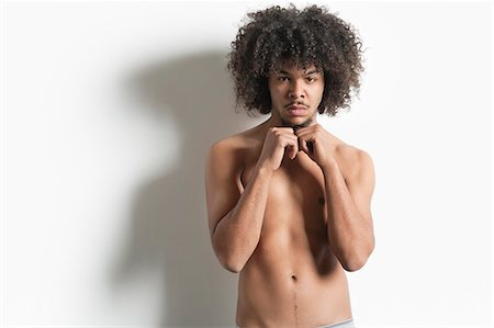 funky - Portrait d'un jeune homme avec pied poing sur fond blanc Photographie de stock - Premium Libres de Droits, Code: 693-06324699