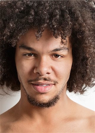 Portrait of a trendy young man with curly hair over white background Stock Photo - Premium Royalty-Free, Code: 693-06324704