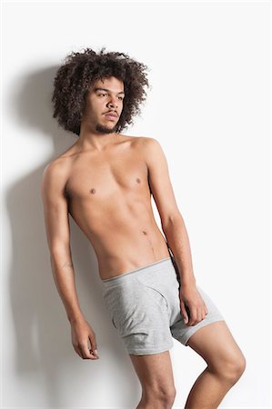 simsearch:693-06379531,k - Partially nude young man with curly hair posing over white background Stock Photo - Premium Royalty-Free, Code: 693-06324702