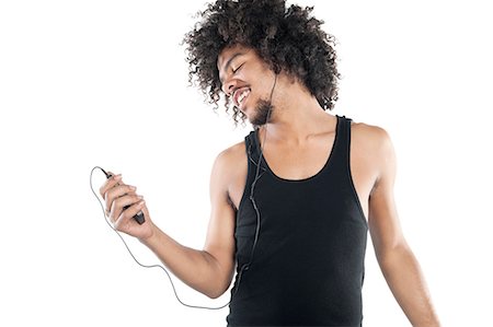 Happy young man listening to mp3 player over white background Foto de stock - Sin royalties Premium, Código: 693-06324714