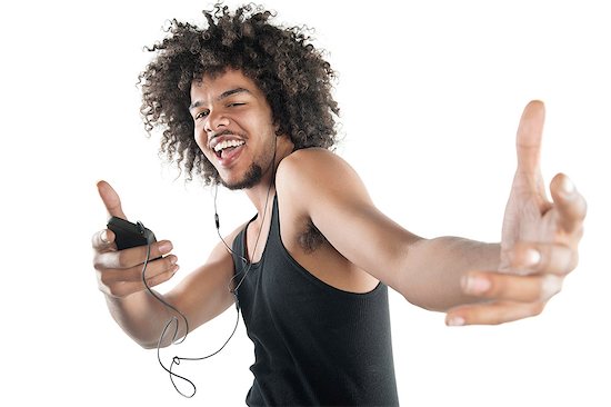 Portrait of a happy young man in vest dancing to tunes of mp3 player over white background Stock Photo - Premium Royalty-Free, Image code: 693-06324715