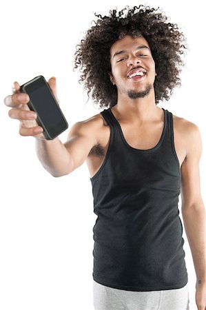 showing - Portrait of a happy young man showing mobile phone over white background Stock Photo - Premium Royalty-Free, Code: 693-06324720