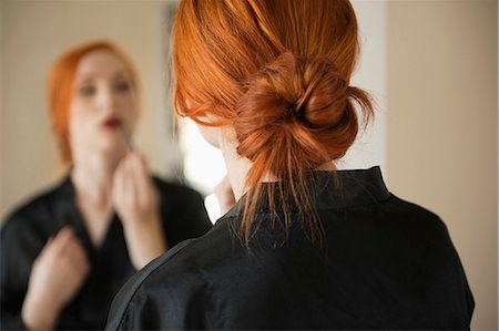 red hair woman rear view - Back view of young woman applying makeup Stock Photo - Premium Royalty-Free, Code: 693-06324738