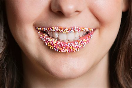 smiling lips - Cropped portrait of Middle Eastern woman with sprinkle candy lips Foto de stock - Sin royalties Premium, Código: 693-06324775