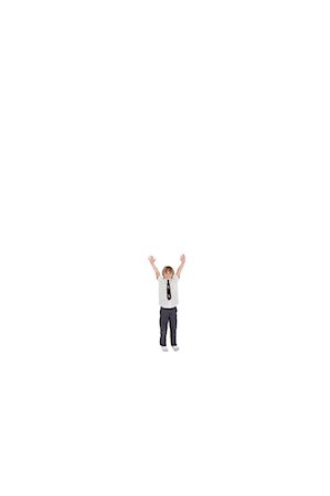 simsearch:693-06324793,k - Elementary boy standing at distance with arms raised over white background Fotografie stock - Premium Royalty-Free, Codice: 693-06324777