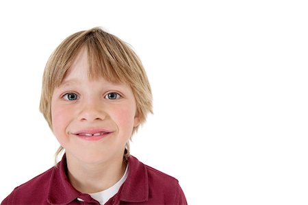 Close-up portrait of a happy school boy over white background Stock Photo - Premium Royalty-Free, Code: 693-06324795