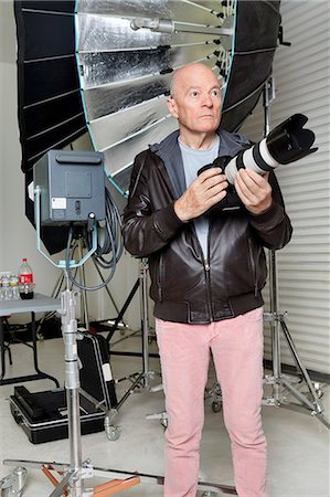 simsearch:693-06324870,k - Front view of senior man with camera in photographer's studio Stock Photo - Premium Royalty-Free, Code: 693-06324865