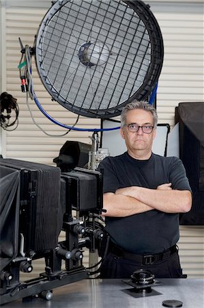 sesión fotográfica - Portrait of a technician with arms crossed standing in photographer's studio Foto de stock - Sin royalties Premium, Código: 693-06324871