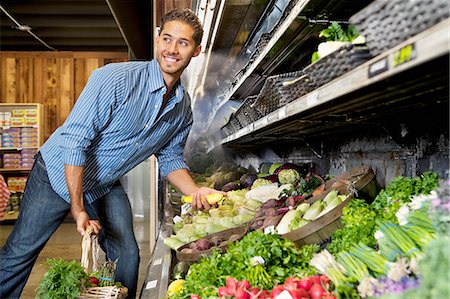 retail shopping baskets usa - Happy young man shopping for vegetables in market Foto de stock - Sin royalties Premium, Código: 693-06324924