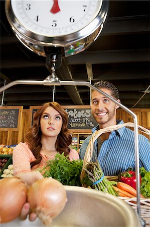 Happy young couple looking at weight scale in supermarket Stock Photo - Premium Royalty-Free, Code: 693-06324921